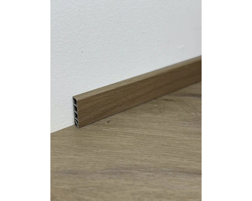 Dřevěná podlahová lišta u zdi