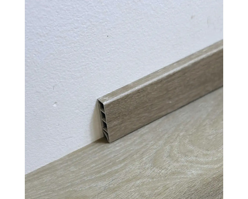 Plastová podlahová lišta s dřevěným dekorem na zdi a podlaze