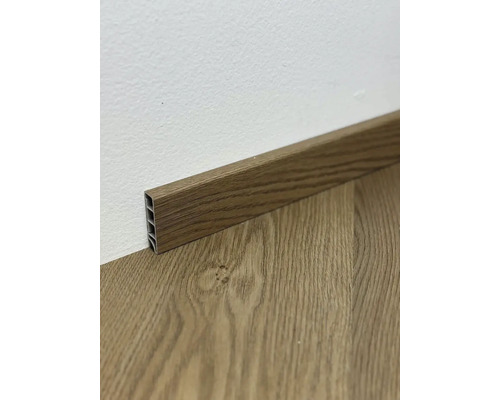 Podlahová lišta s dřevěným vzhledem u stěny