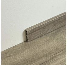 Plastová podlahová lišta s dřevěným vzhledem u zdi