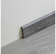 Šedá plastová podlahová lišta na podlaze a na stěně