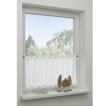 Okno s bílou záclonou a dekorací na parapetu