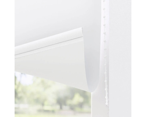 Bílá roleta s řetízkovým ovládáním před oknem