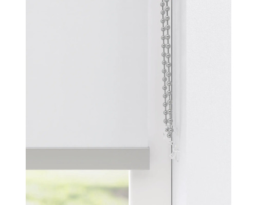 Detail bílé rolety s řetízkovým ovládáním pro dekoraci oken