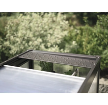 Detailní pohled na skleník s otevřeným střešním oknem pro ventilaci.