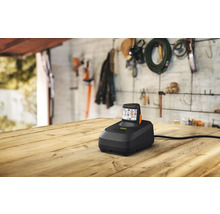 Nabíječka baterií s baterií na dřevěném stole