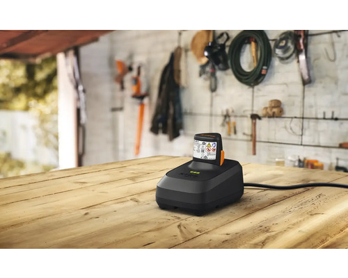 Nabíječka baterií s baterií na dřevěném stole