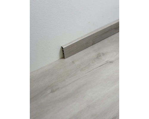 Dřevěná podlahová lišta na zdi