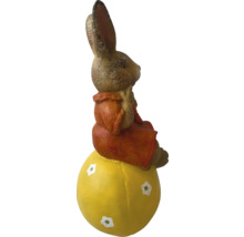 Velikonoční zajíček sedící na žlutém vejci jako dekorace