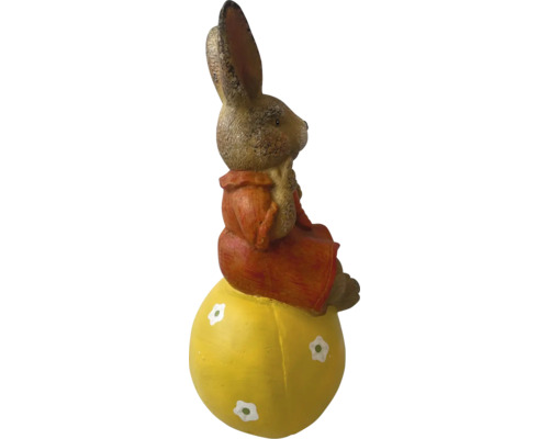 Velikonoční zajíček sedící na žlutém vejci jako dekorace
