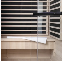 Interiér sauny s dřevěným obložením, skleněnou přední stranou a lavicí s ručníkem