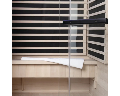 Interiér sauny s dřevěným obložením, skleněnou přední stranou a lavicí s ručníkem