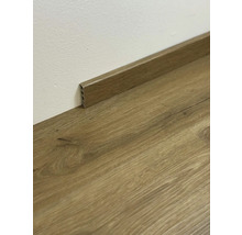 Dřevěná podlahová lišta na dřevěné podlaze u stěny