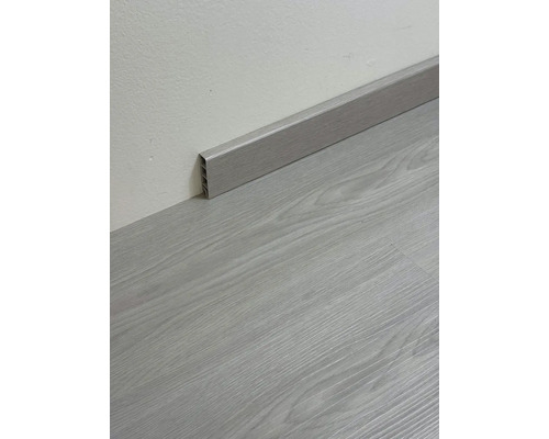 Podlahová lišta imitující dřevo namontovaná na zdi