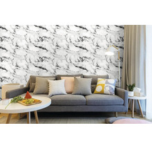 Obývací pokoj s šedou pohovkou a nástěnnými dlaždicemi se vzhledem mramoru