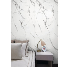 Ložnice s nástěnnými panely se vzhledem mramoru, postelí a nočním stolkem