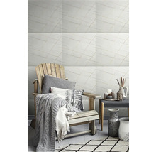 Světlý obývací pokoj s mramorovými obklady, křeslem a dekoracemi pro stylovou atmosféru.