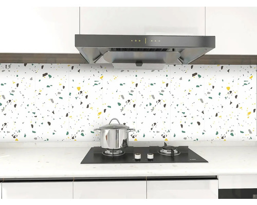 Kuchyňská scéna s dlaždicemi se skvrnitým vzorem, sporákem a odsavačem par.