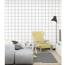 Obývací pokoj s pohovkou, křeslem, lampou, stolem a tapetou se čtvercovým vzorem