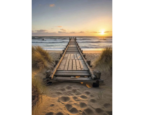 Dřevěná lávka vedoucí na pláž a k moři při západu slunce.