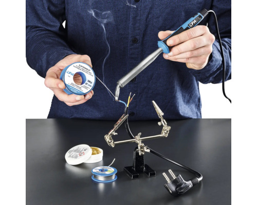 Elektrická páječka CFH E 100 Osoba pájí kabely páječkou, pájecím cínem a pájecí pastou na pracovní ploše.