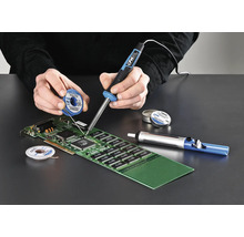 Osoba pájí desku plošných spojů pomocí páječky, pájecího drátu a odsávačky cínu.