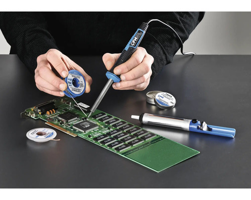 Osoba pájí desku plošných spojů pomocí páječky, pájecího drátu a odsávačky cínu.