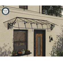 Průhledná vchodová stříška s černými zdobenými kovovými konzolami namontovaná nad vchodovými dveřmi a oknem, registrovaný design.