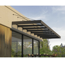 Moderní zastřešení terasy ze skla a tmavého kovu namontované na stěnu domu s dřevěným obkladem nad venkovním posezením.