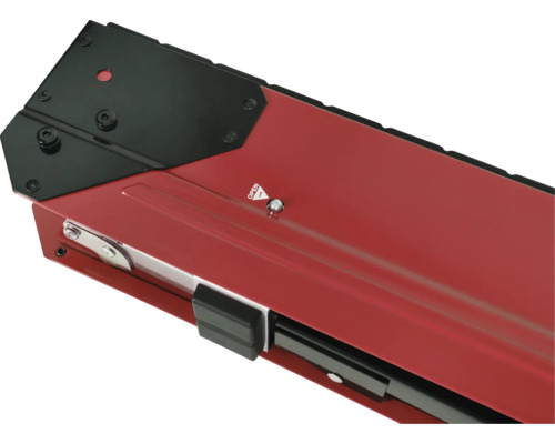 Detailní pohled na červený držák okenního parapetu s černým krytem a upevňovacími prvky