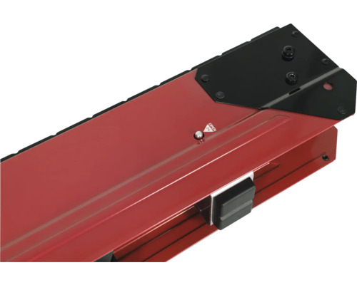 Detailní pohled na řezačku dlaždic s červenou základnou a černým prvkem