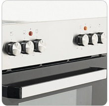 Detailní pohled na stříbrný sporák s ovládacími knoflíky a rukojetí