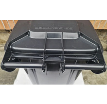 Detailní pohled na popelnici s víkem a madlem.