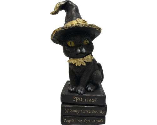 Dekorativní kočičí figurka s čarodějnickým kloboukem na stohu knih jako halloweenská dekorace