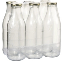 Šest prázdných skleněných lahví s uzávěrem zabalených ve fólii