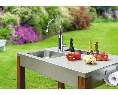 Venkovní kuchyně s dřezem, baterií, zeleninou, šampaňským a držákem papírových ručníků na zahradě