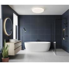 Moderní koupelna s volně stojící vanou, umyvadlem a osvětleným zrcadlem