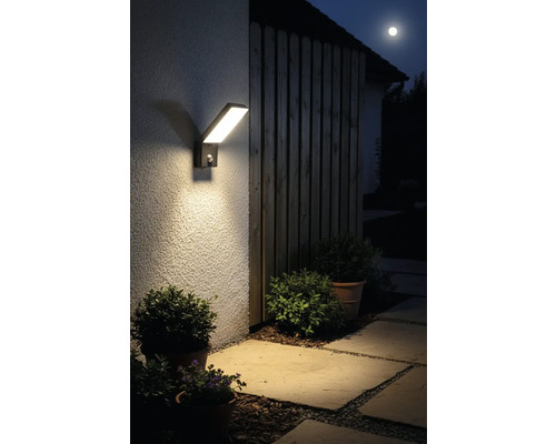 Moderní LED venkovní svítidlo s pohybovým senzorem na stěně domu v noci