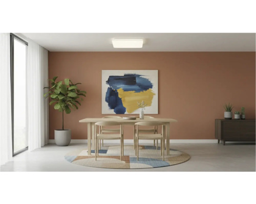 Světlá jídelna s dřevěným stolem, židlemi a stropním svítidlem.