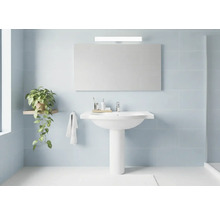 Světlá koupelna s umyvadlem, zrcadlem, rostlinou a ručníkem