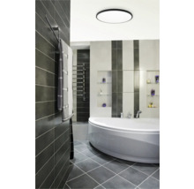 Moderní koupelna s vanou, topným žebříkem a šedými dlaždicemi