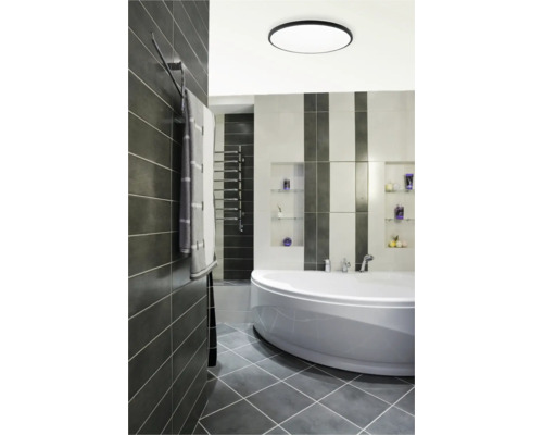 Moderní koupelna s vanou, topným žebříkem a šedými dlaždicemi