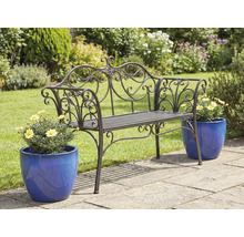 Zdobená kovová zahradní lavička s květináči na zahradní terase