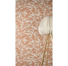 Tapeta se vzorem borovic v pozadí, v popředí moderní stojací lampa s plisovaným stínidlem a dřevěnýma nohama.