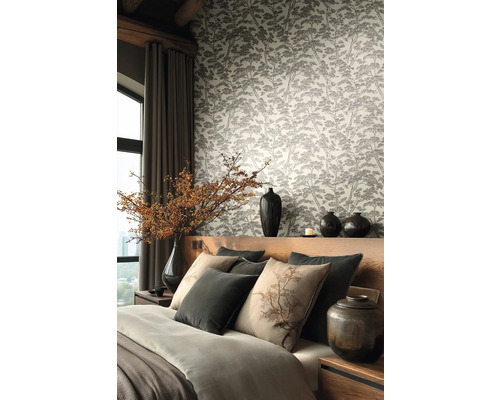 Moderní ložnice s vliesovou tapetou s motivem lesa, dřevěná postel s šedými a béžovými polštáři a dekorativními vázami.