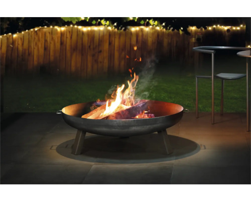 Ohniště s hořícím dřevem na zahradě