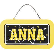 Žlutá jmenovka na dveře se jménem Anna v písmenech s tečkovaným vzorem, s kovovým řetízkem na zavěšení a motivem hvězd.