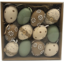 Sada dvanácti velikonočních vajíček s různými vzory jako tečky, květy a pruhy v krabičce se slámou.