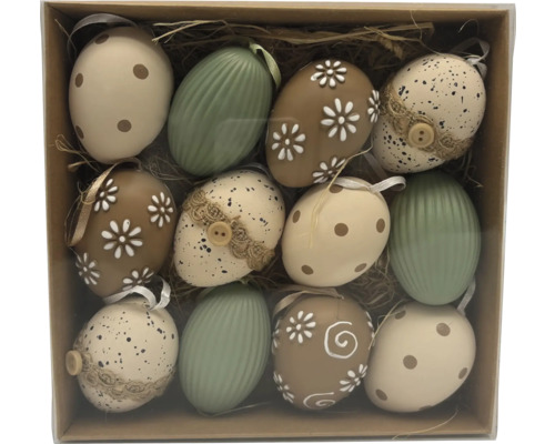 Sada dvanácti velikonočních vajíček s různými vzory jako tečky, květy a pruhy v krabičce se slámou.