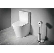 Stojící WC kombi z keramiky s nádržkou a sedátkem vedle chromovaného stojanu na toaletní papír a WC kartáče v koupelně.